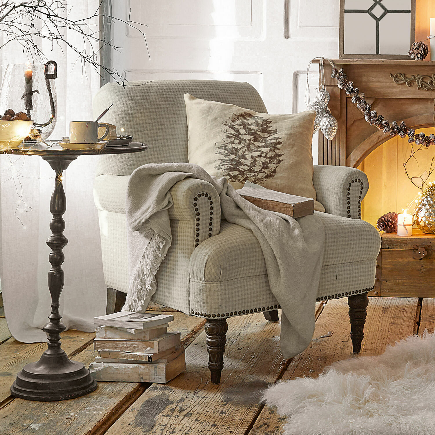 Sillón Danvers Sillón beige a cuadros con patas de madera y cojín decorativo en sala con chimenea