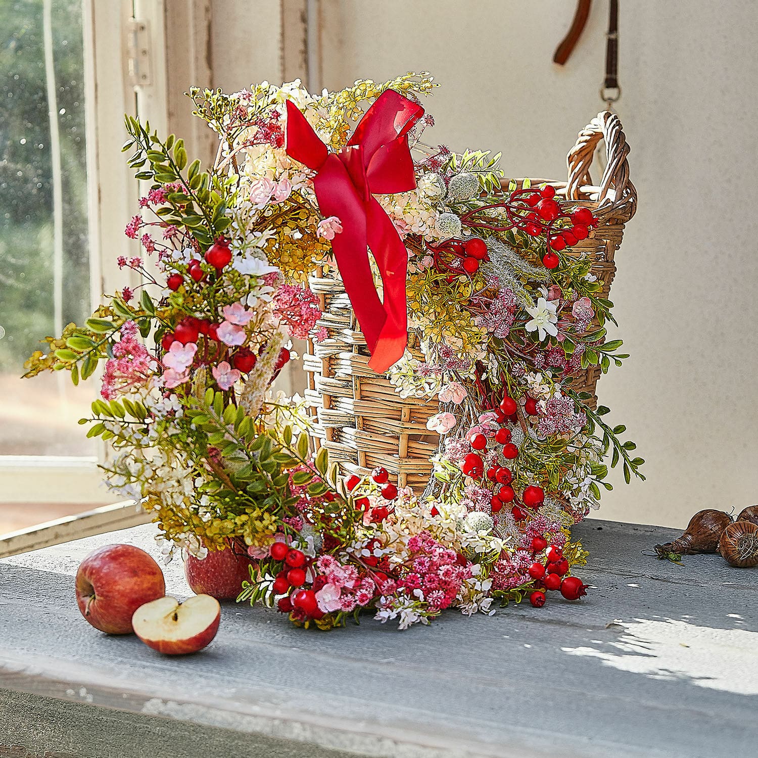Corona Selivane Corona decorativa con bayas rojas y flores rosas sobre cesta de mimbre en mesa