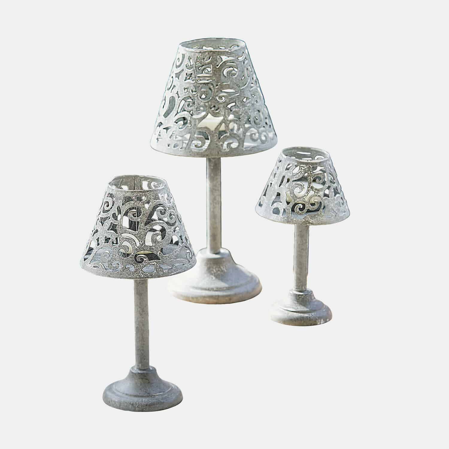 Conjunto de tres candelabros de metal plateado con diseño calado para decoración interior