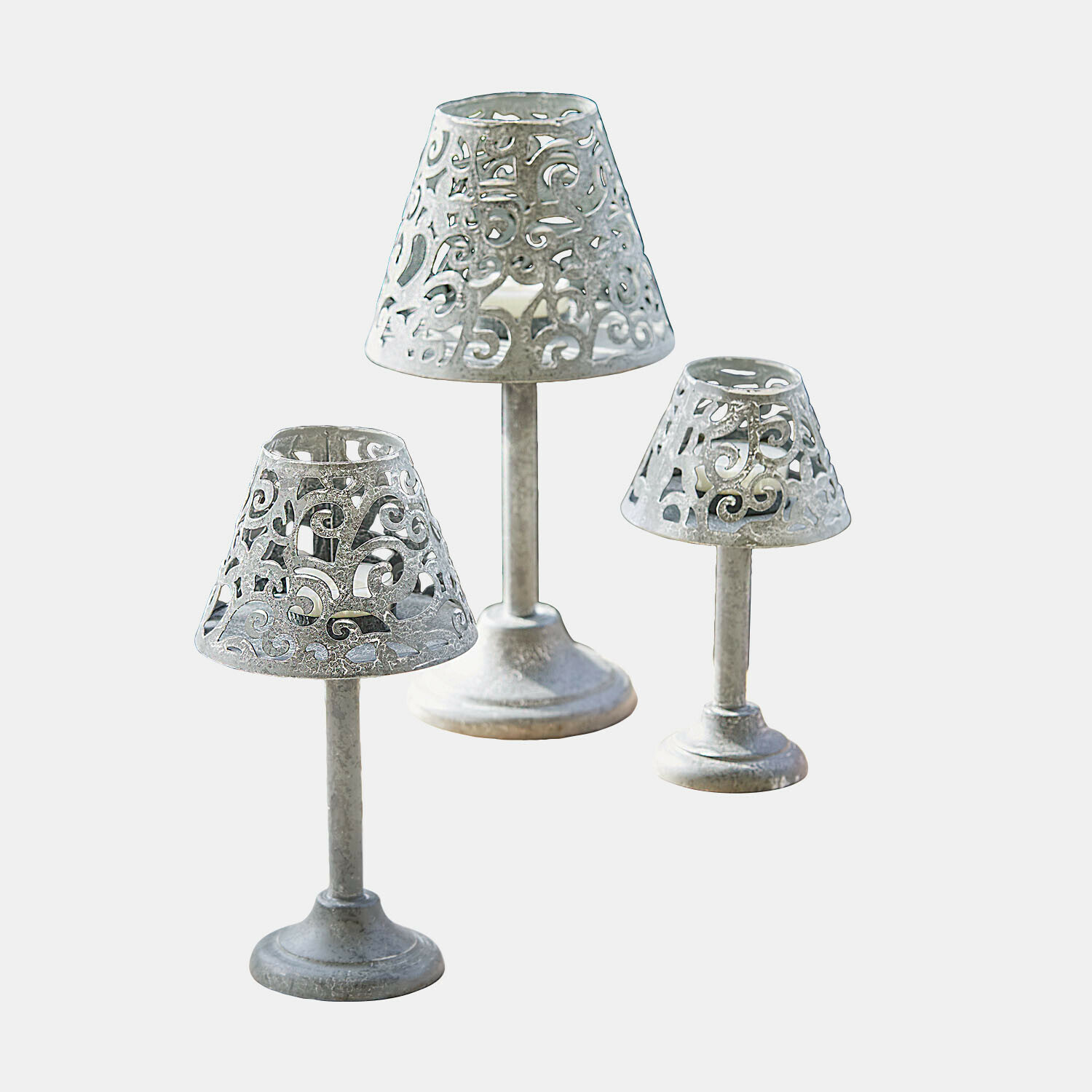 Set de 3 portavelas Belori Conjunto de tres candelabros de metal plateado con diseño calado para decoración interior