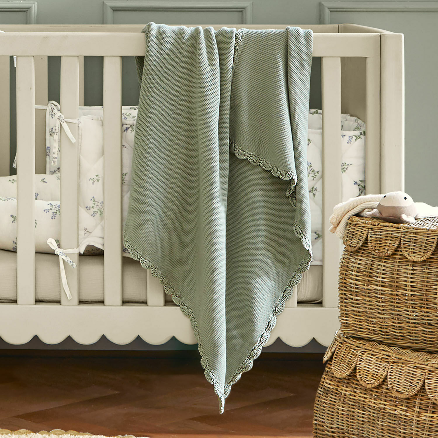 Plaid Nymariel Manta verde suave de algodón con borde de encaje sobre cuna beige, decoración habitación infantil
