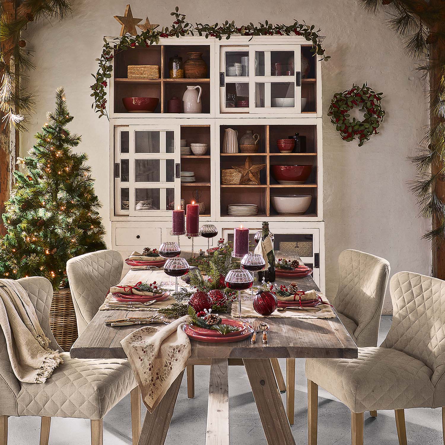 Mesa rústica de madera con sillas beige acolchadas y decoración navideña en comedor