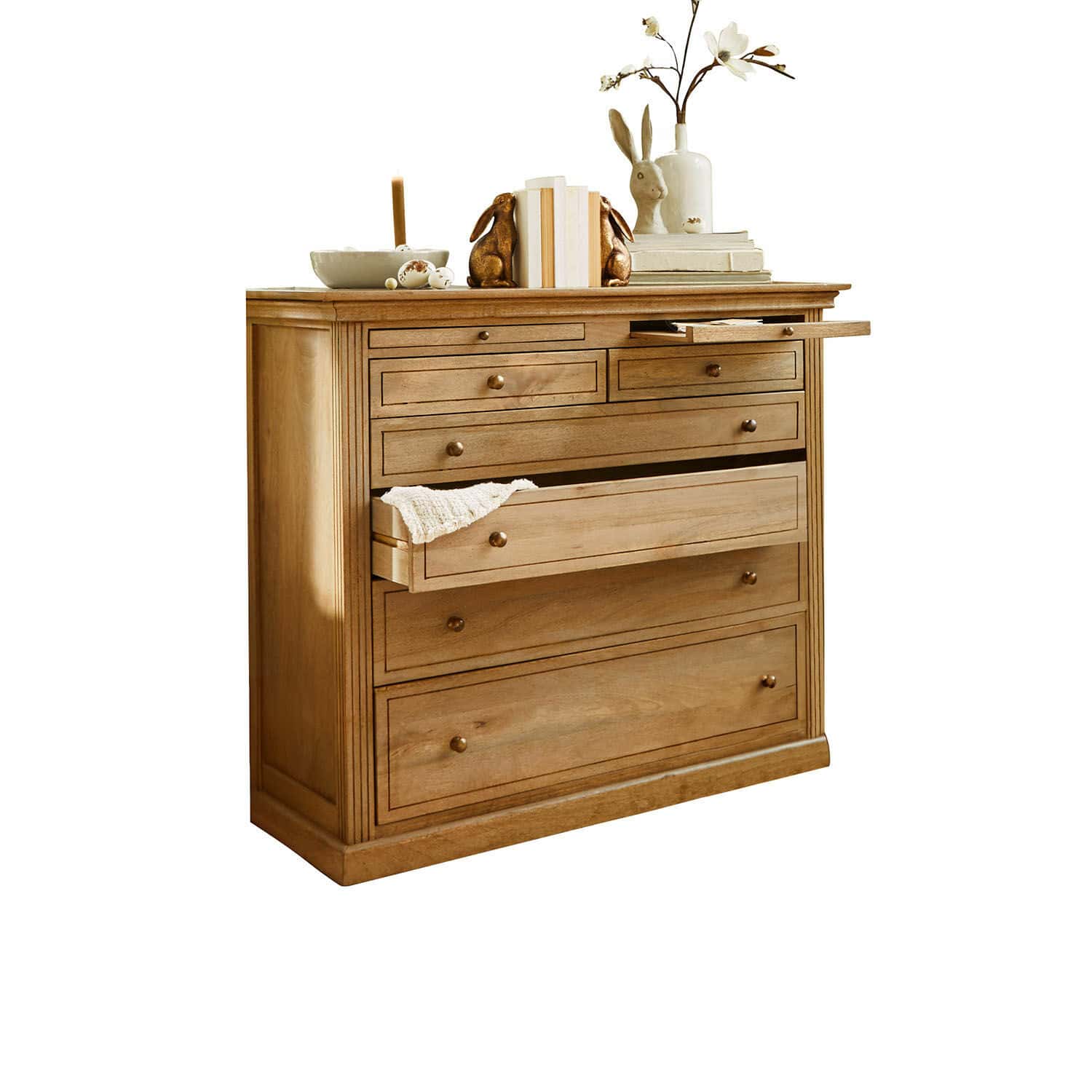 Cómoda Espoirin Cómoda de madera natural con varios cajones y decoraciones encima, color madera clara