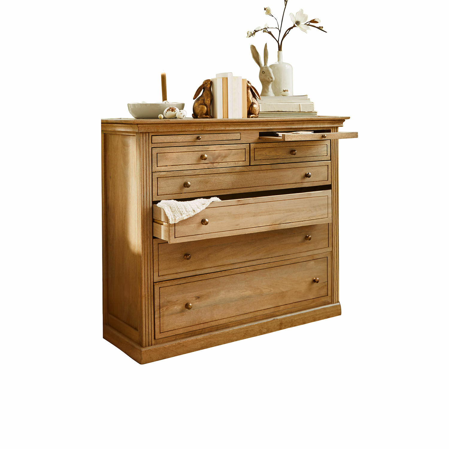 Cómoda Espoirin Cómoda de madera natural con varios cajones y decoraciones encima, color madera clara