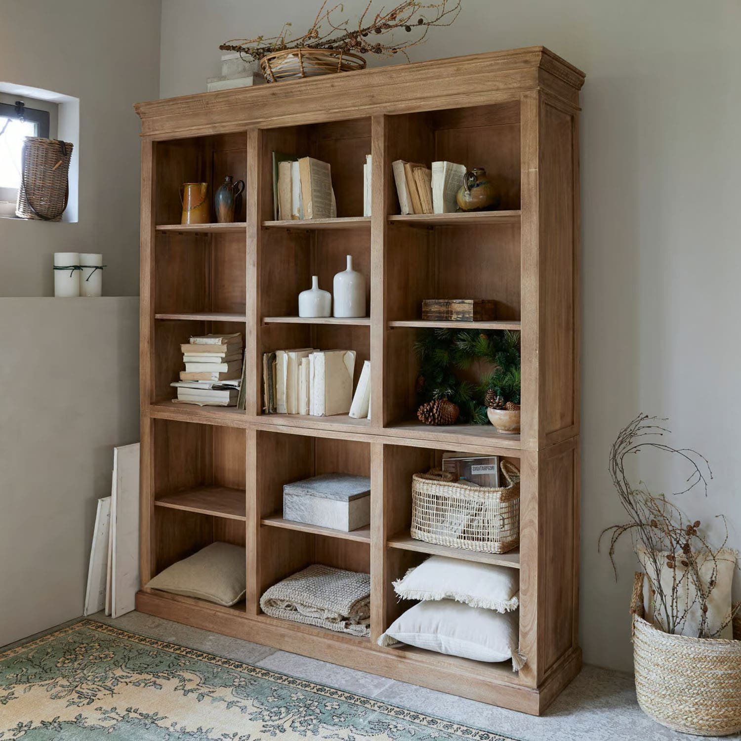 Estantería de madera natural con libros y decoraciones, estilo rústico para salón acogedor