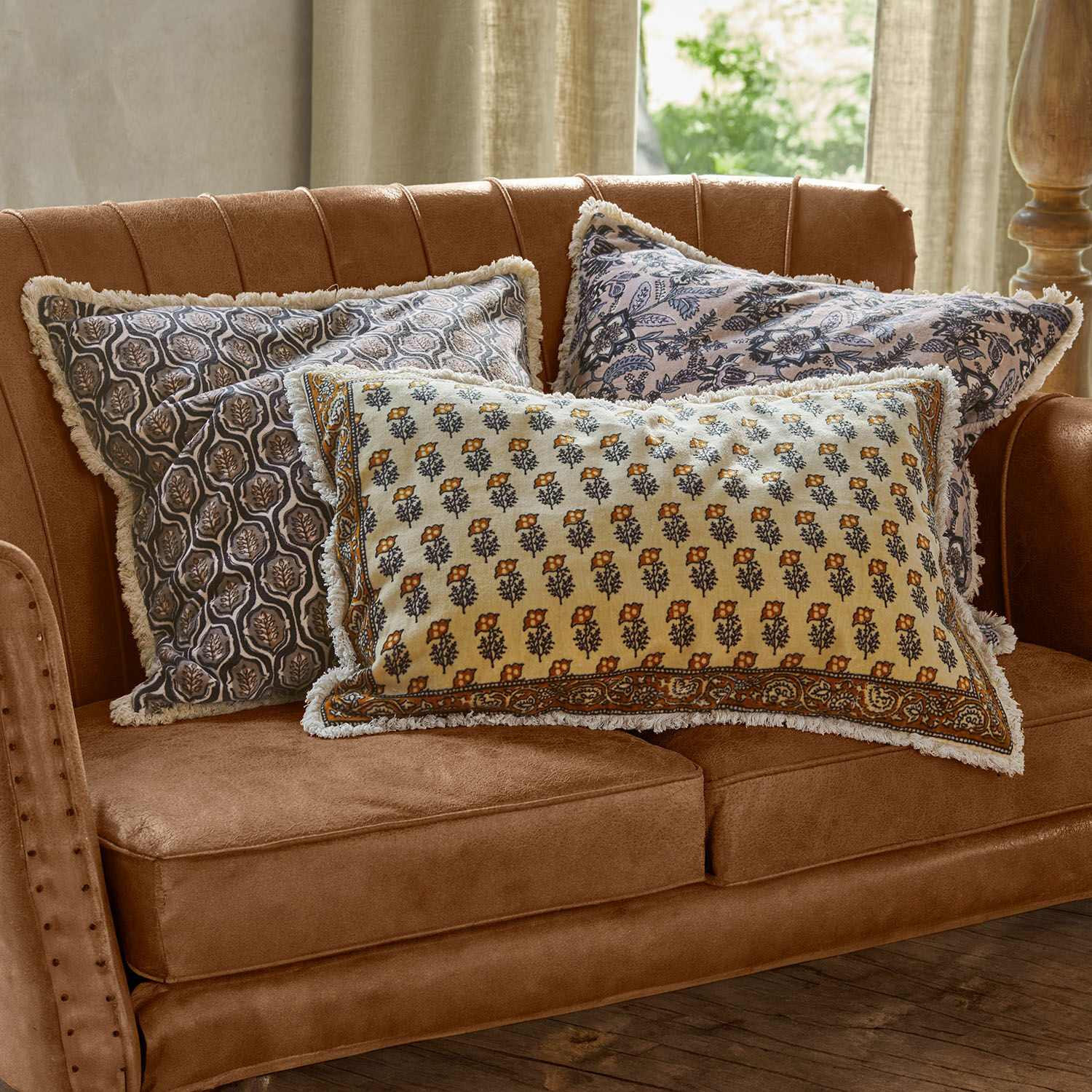 Set de 3 fundas de cojín Zandora Tres cojines decorativos de algodón con estampado floral sobre sofá marrón para sala