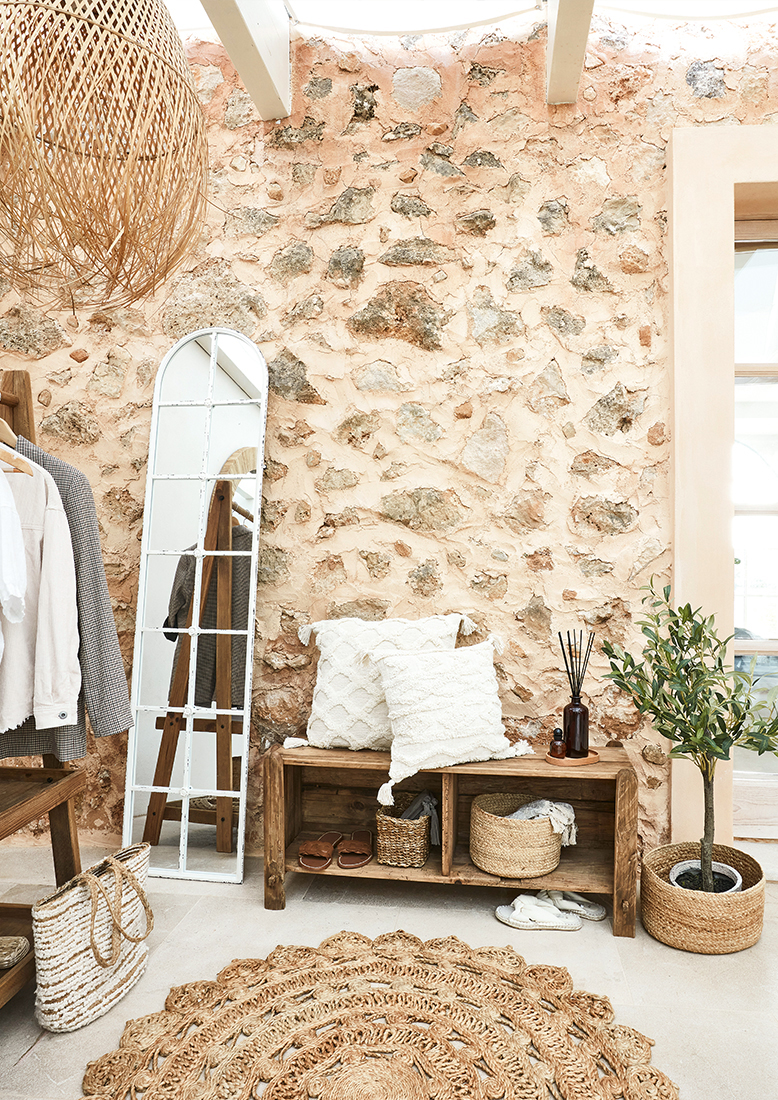 Rincón acogedor con banco de madera, cojines blancos y alfombra natural de yute estilo bohemio