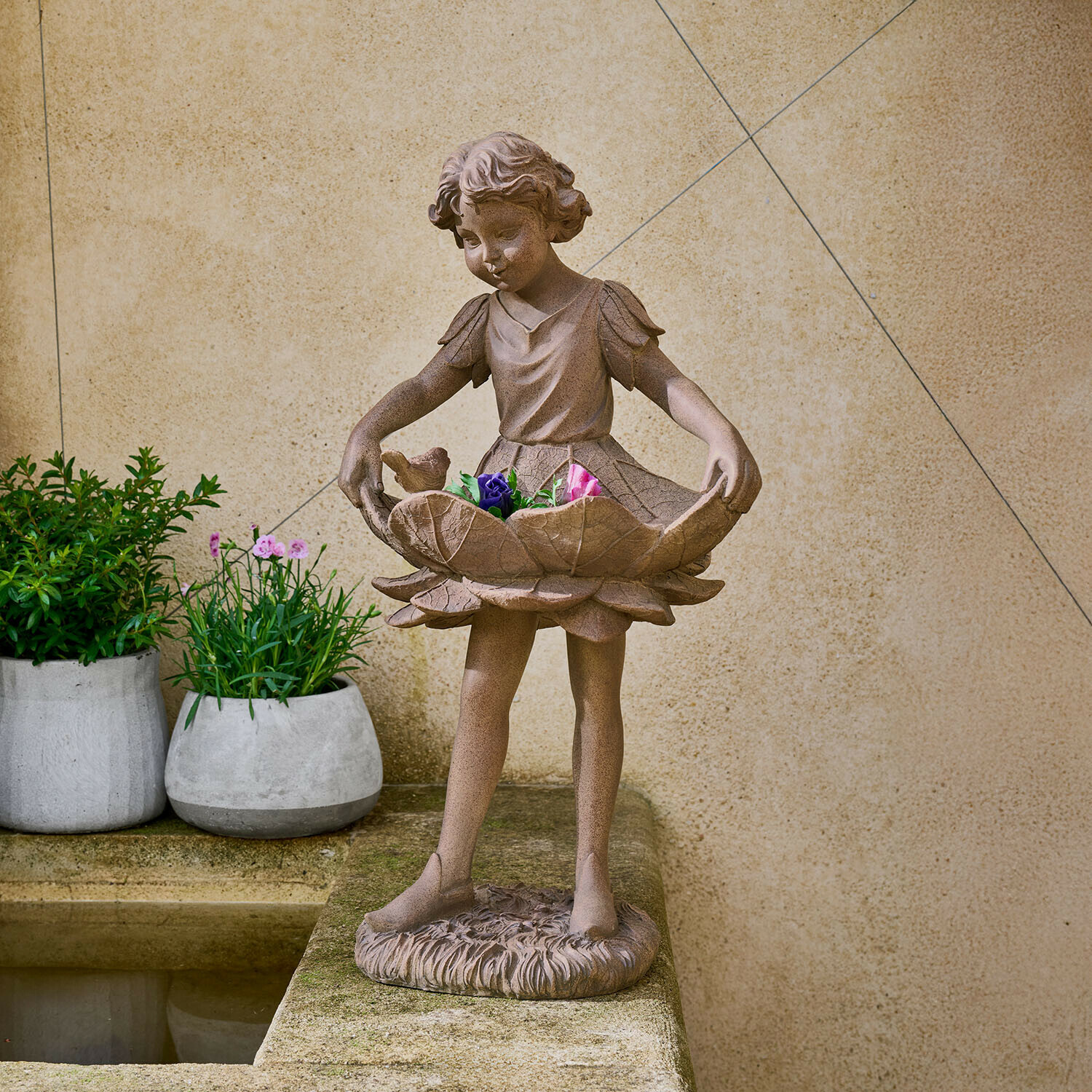 Figura decorativa Aimorise Figura de niña de piedra marrón sosteniendo un cuenco floral con flores de colores en jardín