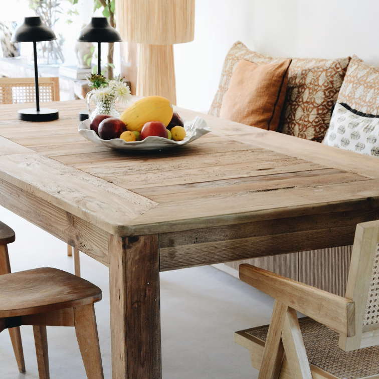 Mesa de comedor rústica de madera con frutero y lámparas de mesa en interior luminoso