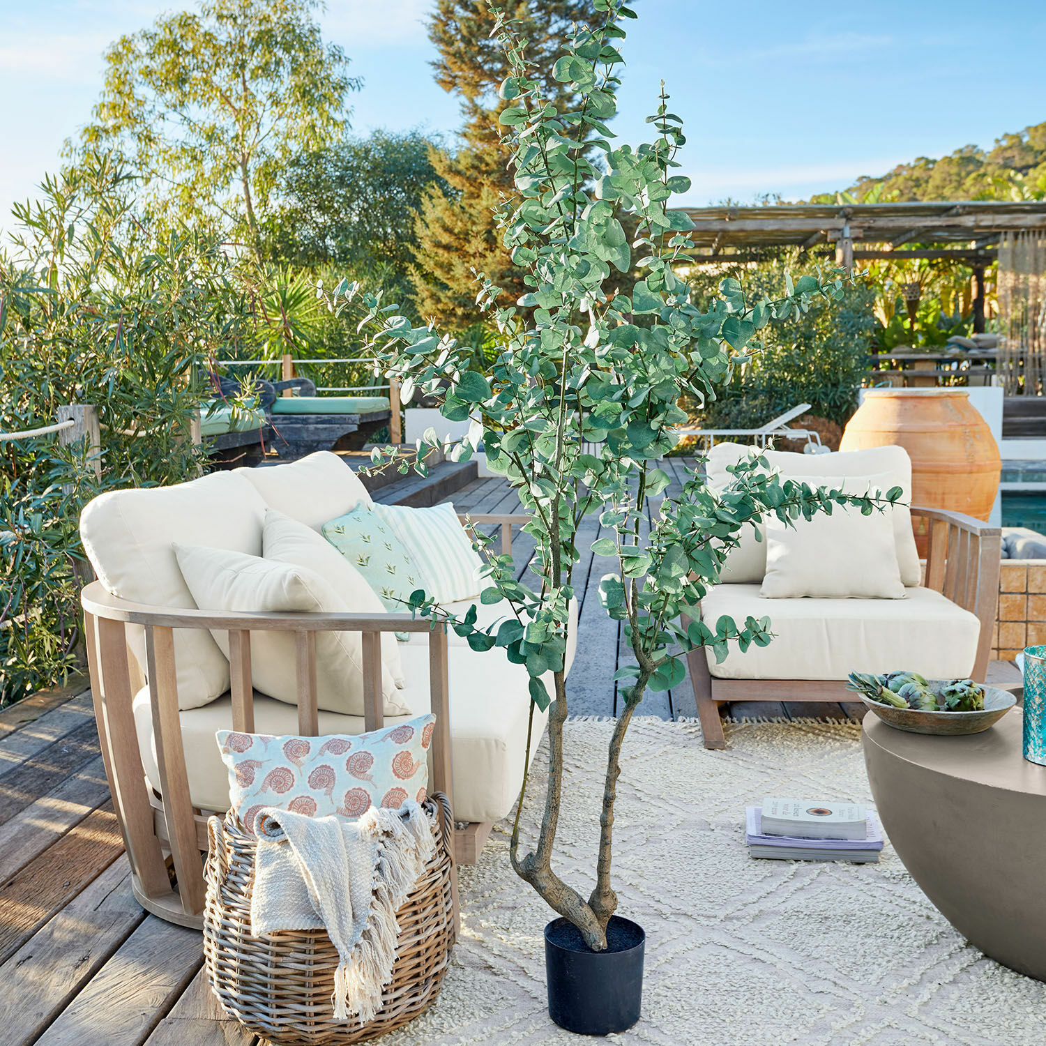 Planta decorativa en maceta Dorevi Planta artificial grande de eucalipto en maceta negra en terraza con muebles de jardín y decoraciones