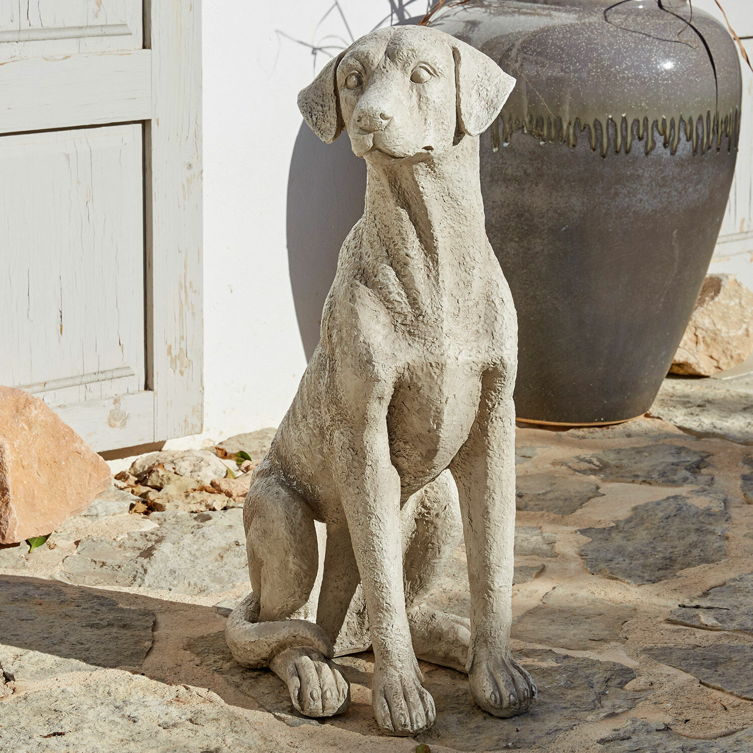 Perro decorativo Elliot Escultura decorativa de perro de hormigón gris sobre suelo de piedra para jardín