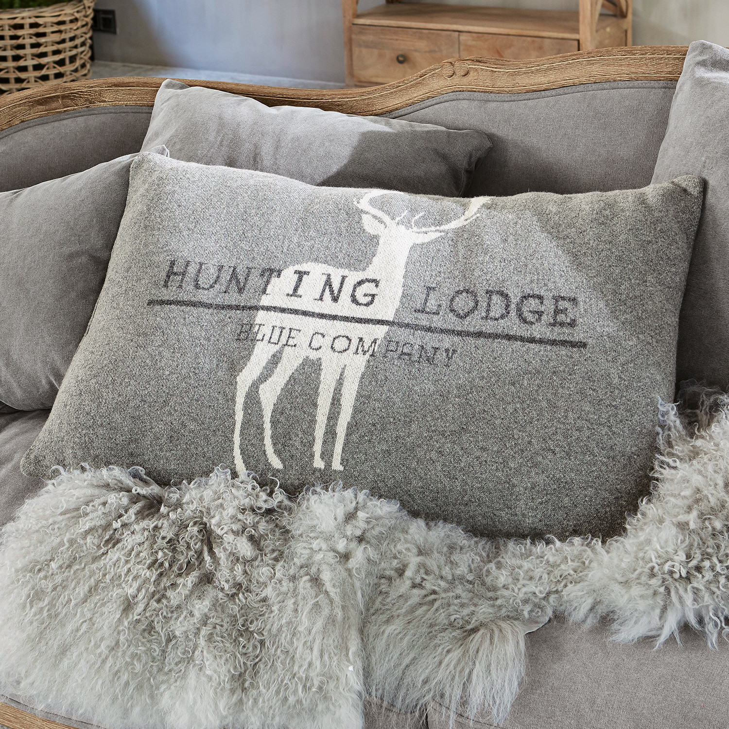 Cojín Lodge Cojín decorativo gris con diseño de ciervo y texto sobre sofá suave con manta de piel