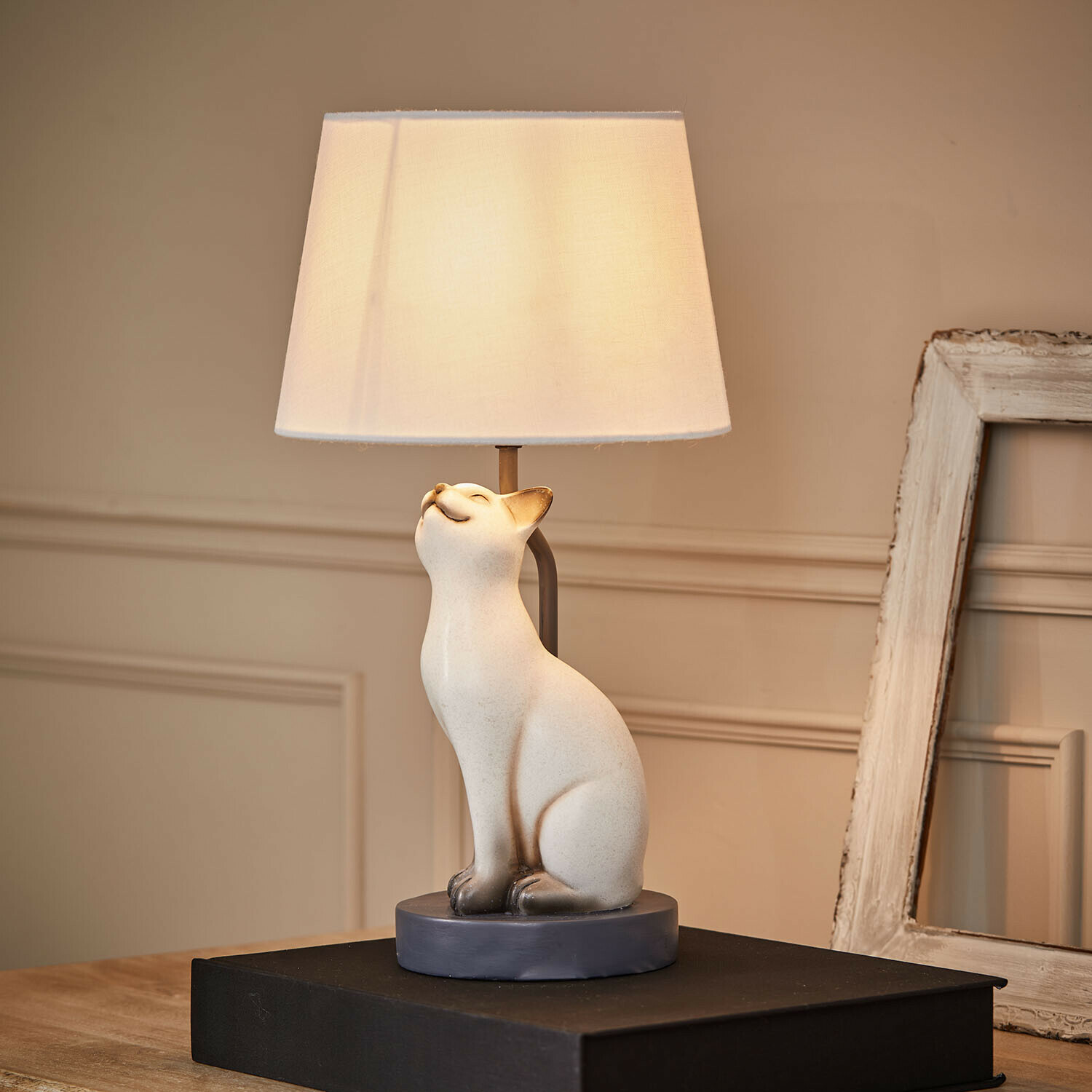 Lámpara de mesa con base de cerámica blanca en forma de gato y pantalla crema para salón