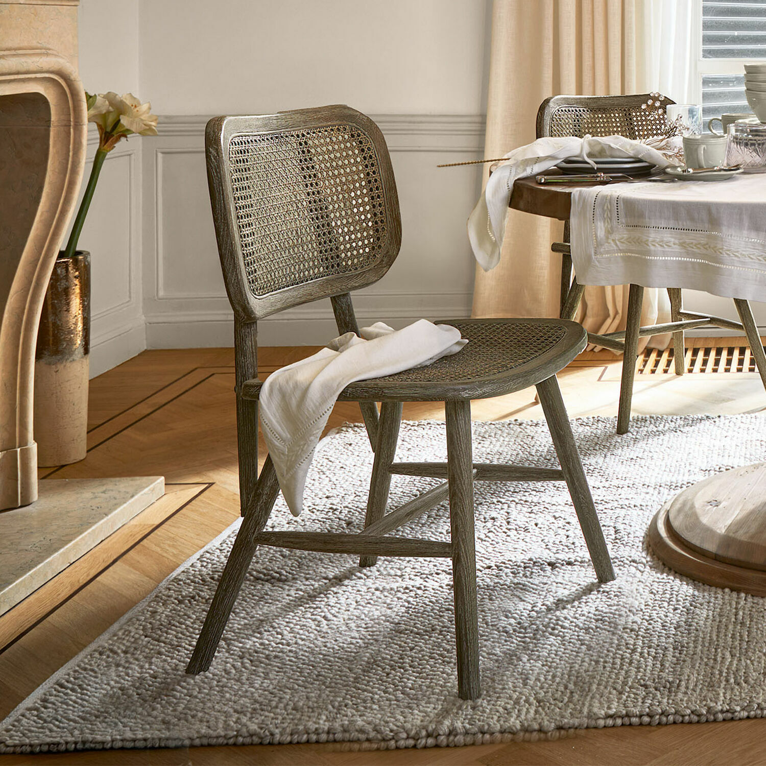 Silla Caelwyn Silla de comedor de madera y ratán gris sobre alfombra, estilo rústico elegante