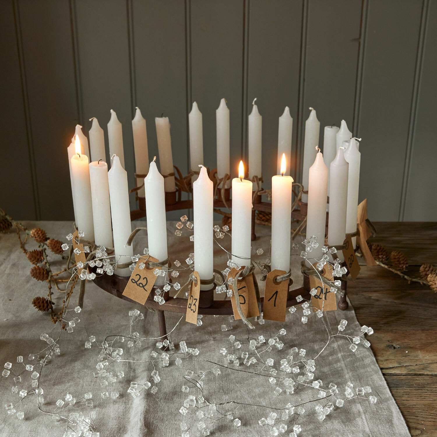 Corona de velas Margarit Corona de Adviento de metal con 24 velas blancas numeradas sobre mantel de lino natural