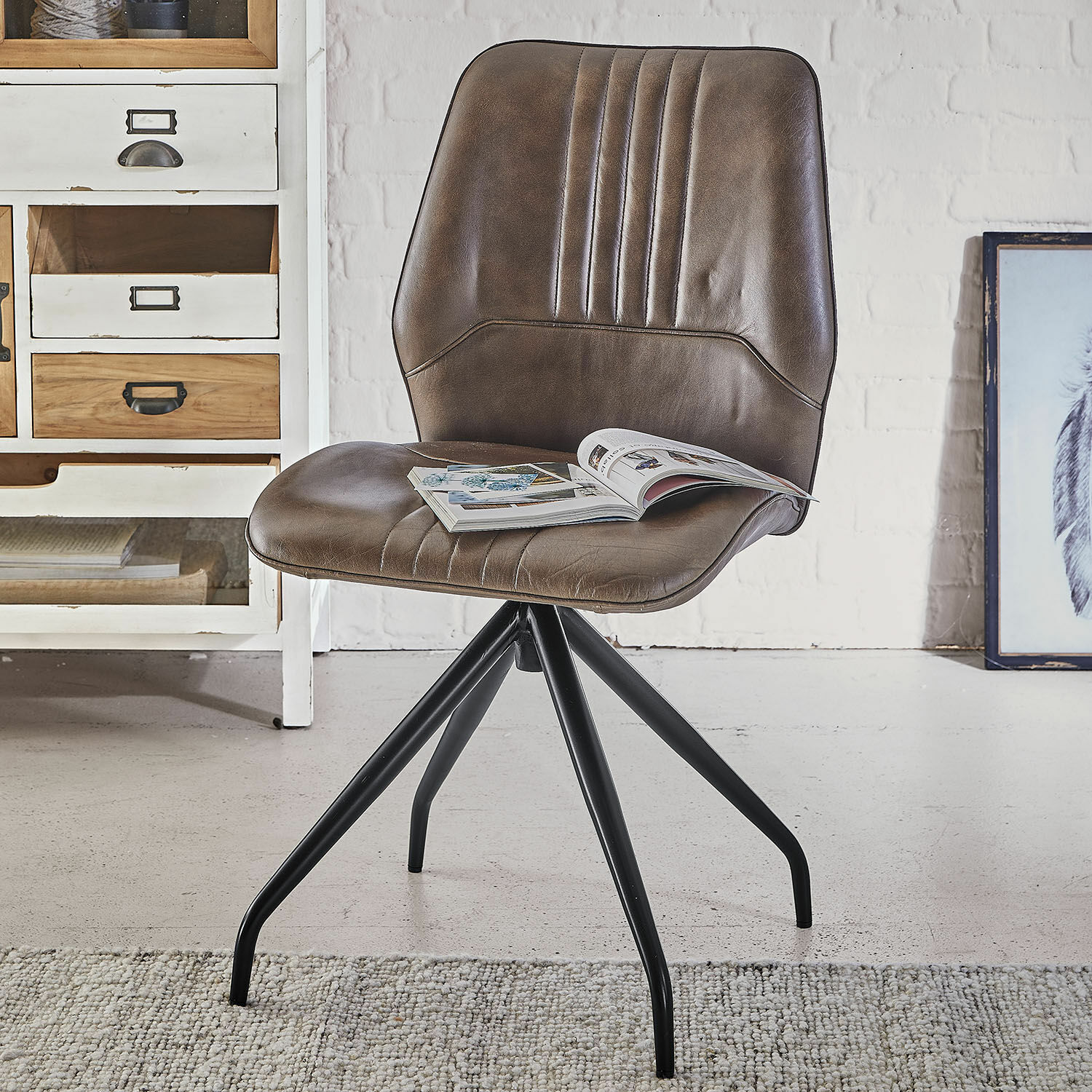 Silla marrón de cuero sintético con base metálica negra, diseño moderno para salón o oficina