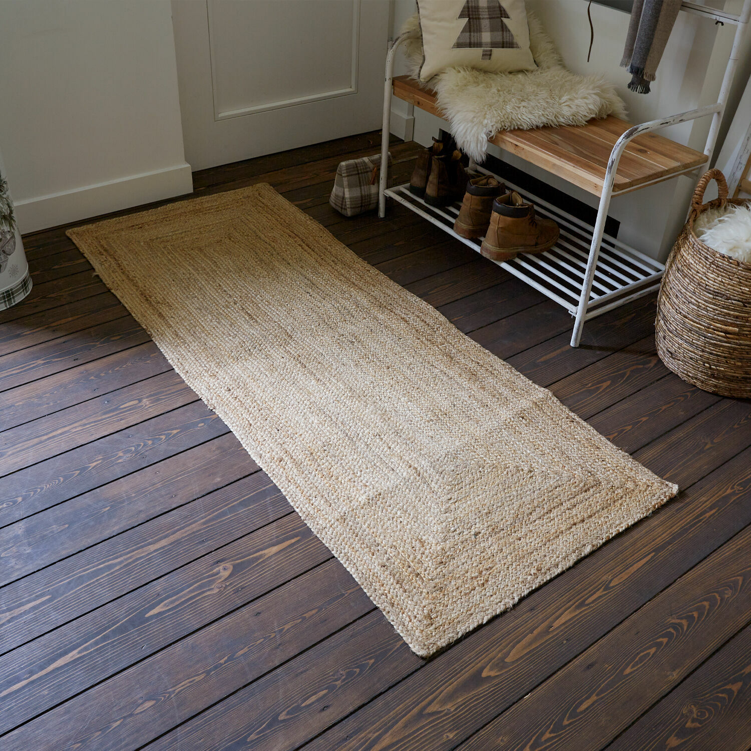 Alfombra Révalaine Alfombra natural beige de yute sobre suelo de madera oscura en un recibidor acogedor