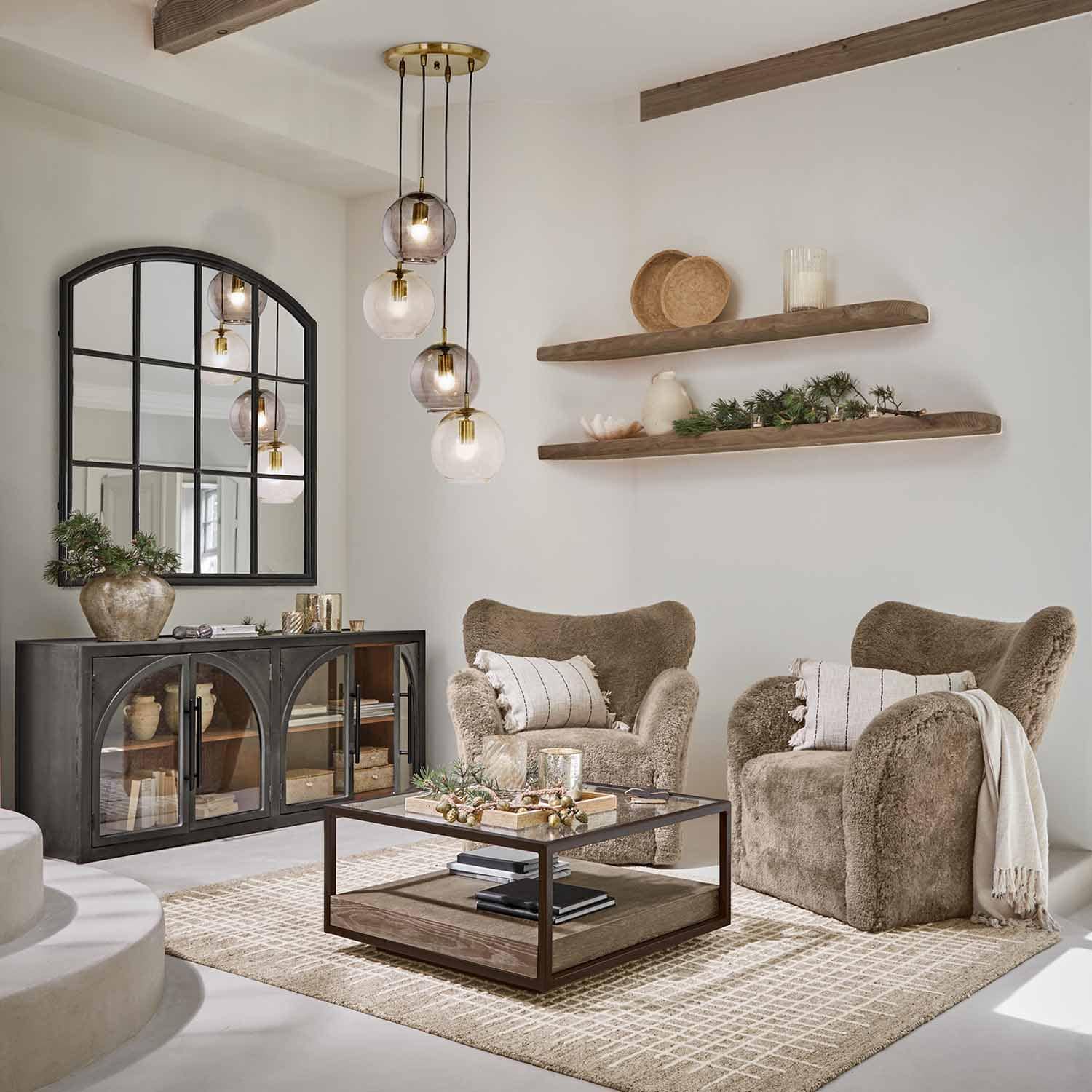 Sala acogedora con dos sillones marrones de material suave y mesa de centro de madera y metal
