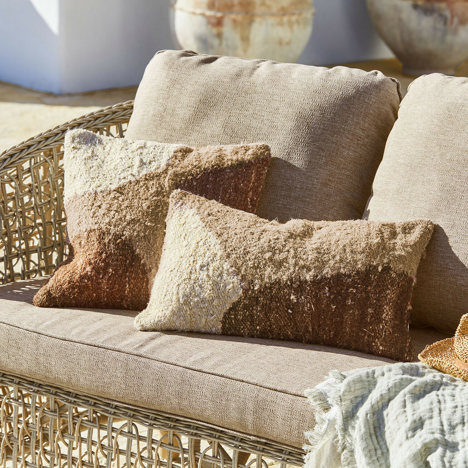 Set de 2 fundas de cojín Everholt Sofá de mimbre beige con cojines suaves en tonos marrón y crema, manta textil decorativa