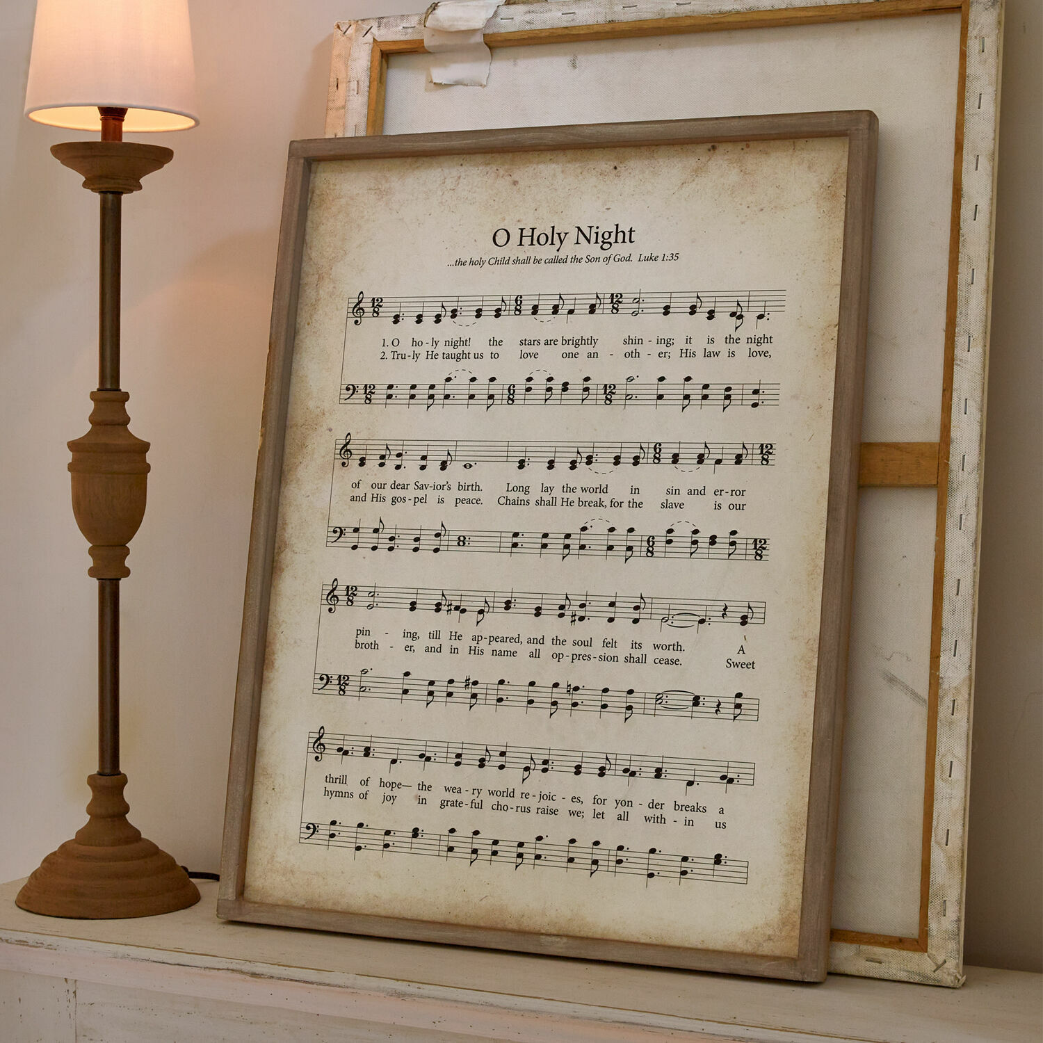 Cuadro Holy Night Cuadro con partitura y letra de O Holy Night en marco de madera junto a lámpara