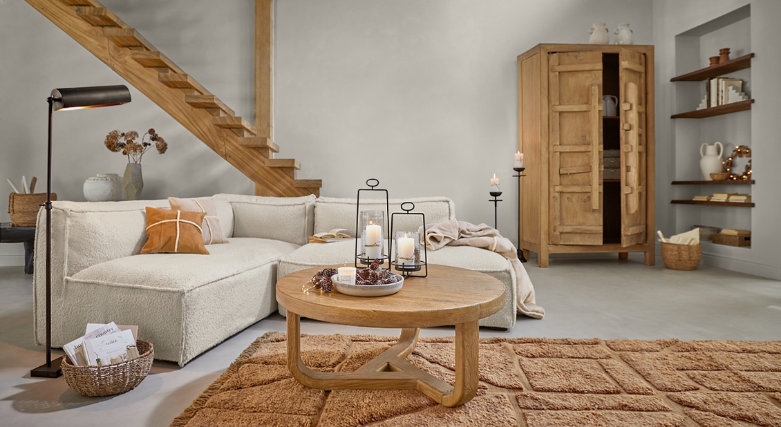 Salón acogedor con sofá beige, mesa de madera y alfombra, iluminación moderna y decoración