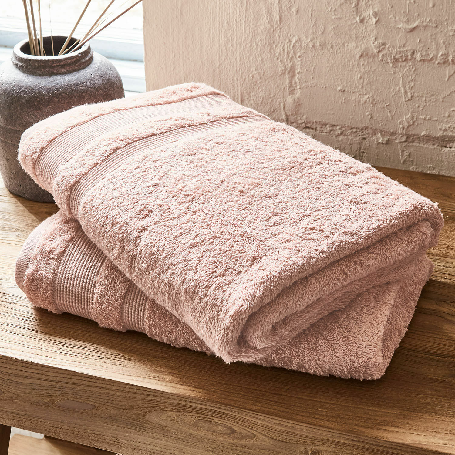 Set de 2 toallas de baño Bourogne Toalla de algodón suave rosa sobre mesa de madera, ideal para baño y uso diario
