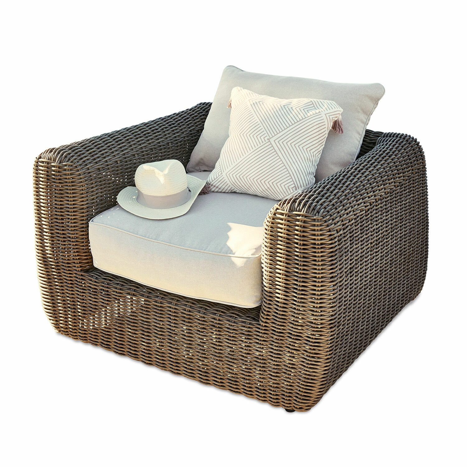 Sillón de ratán marrón con cojines gris claro y cojín decorativo con patrón geométrico