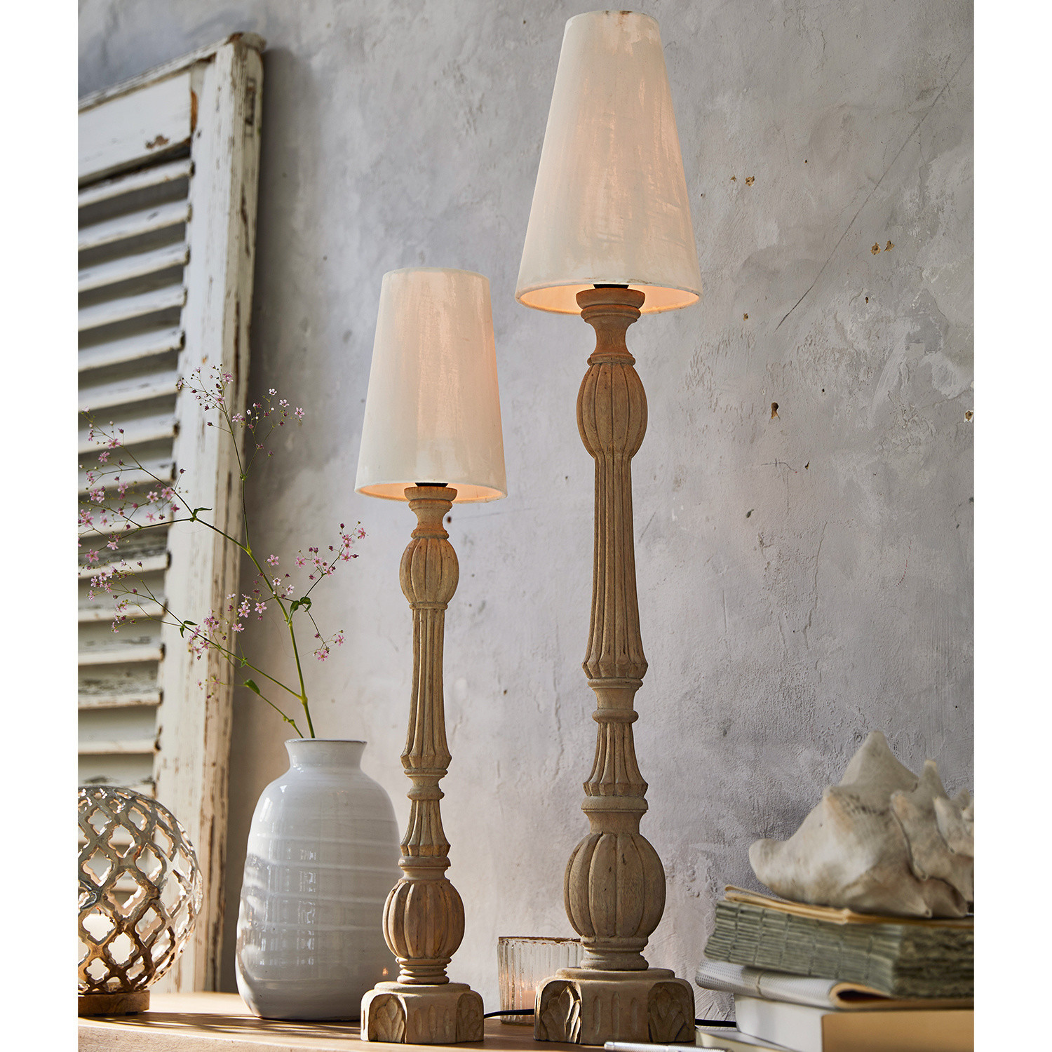 Set de 2 lámparas de mesa Tori Dos lámparas de mesa de madera con pantallas blancas sobre fondo rústico, decoración interior