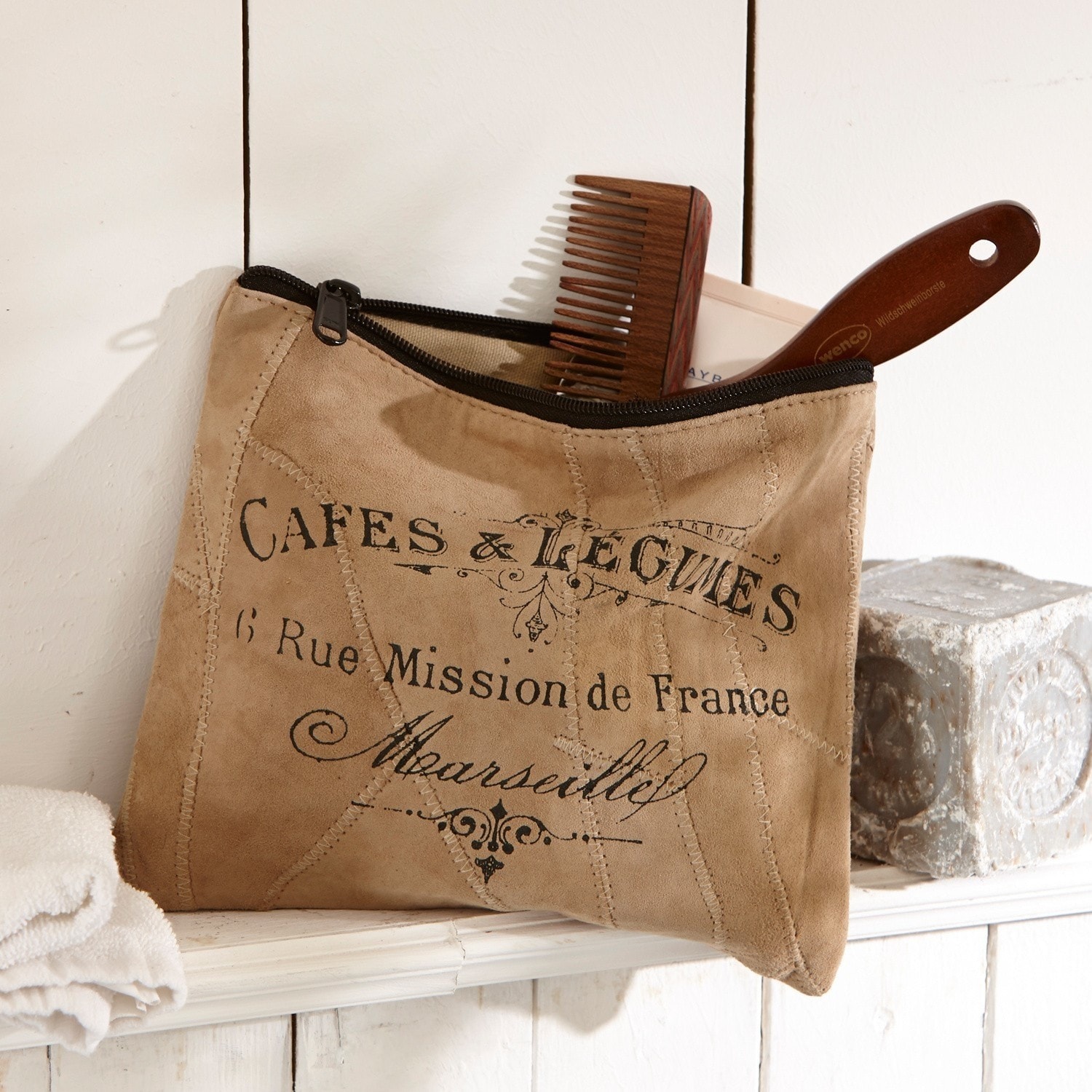 Bolsa pequeña Jeannice Neceser beige de ante con cremallera negra y estampado francés, peine de madera visible en estante