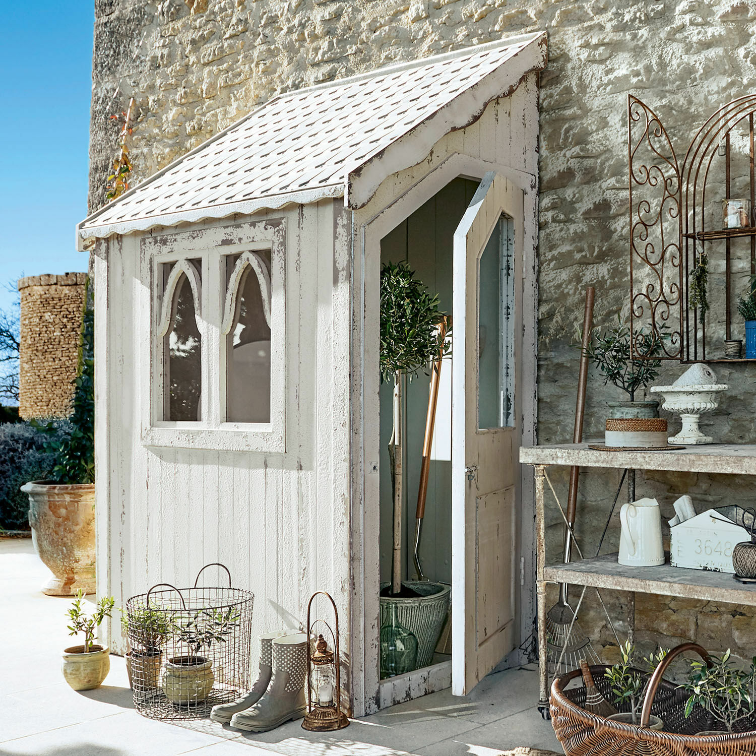 Caseta de jardín Lettret Caseta de jardín de madera blanca con ventanas y puerta abierta, plantas y herramientas decorativas