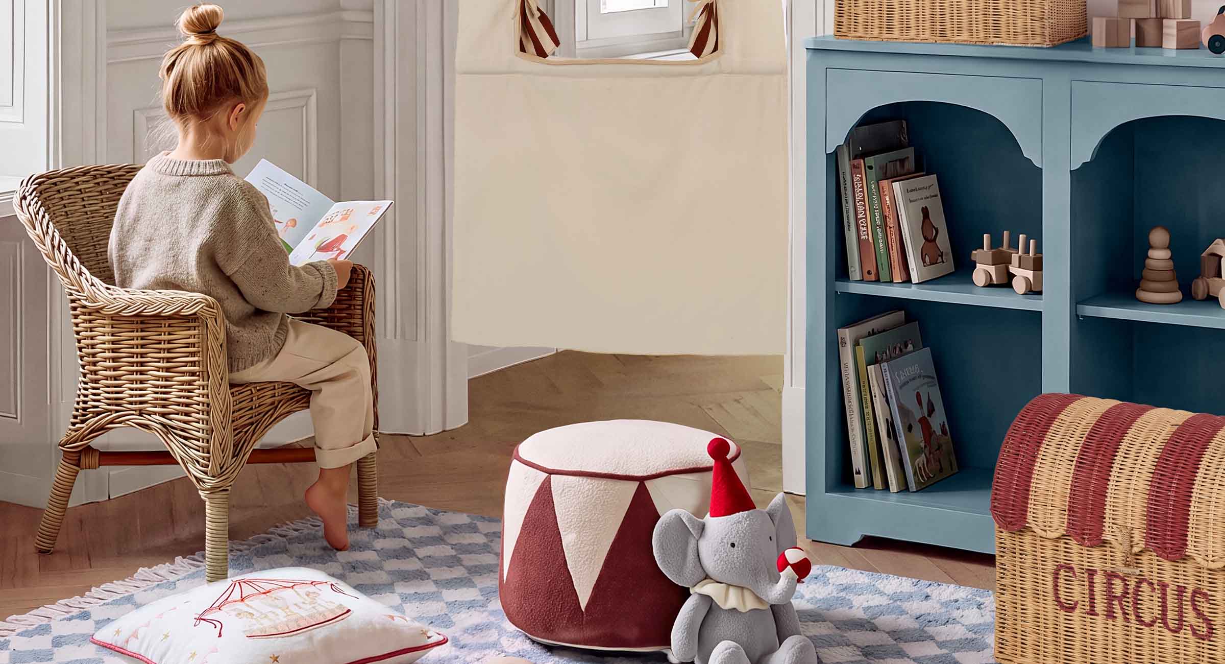 Rincón infantil acogedor con sillón de mimbre, estantería azul y elefante de peluche estilo circo