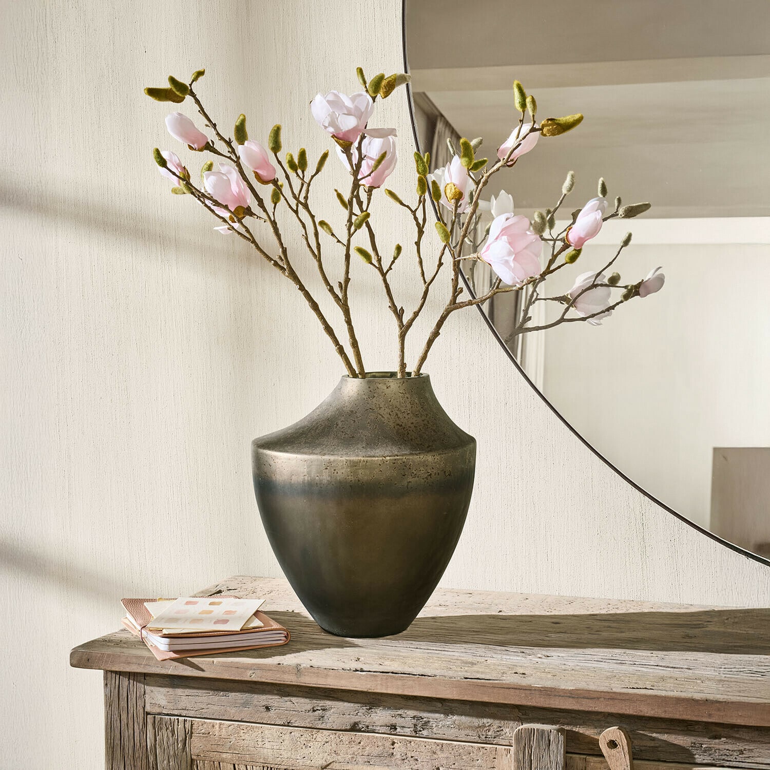 Jarrón Tavris Jarrón metálico marrón oscuro con ramas de flores rosas sobre mesa de madera rústica