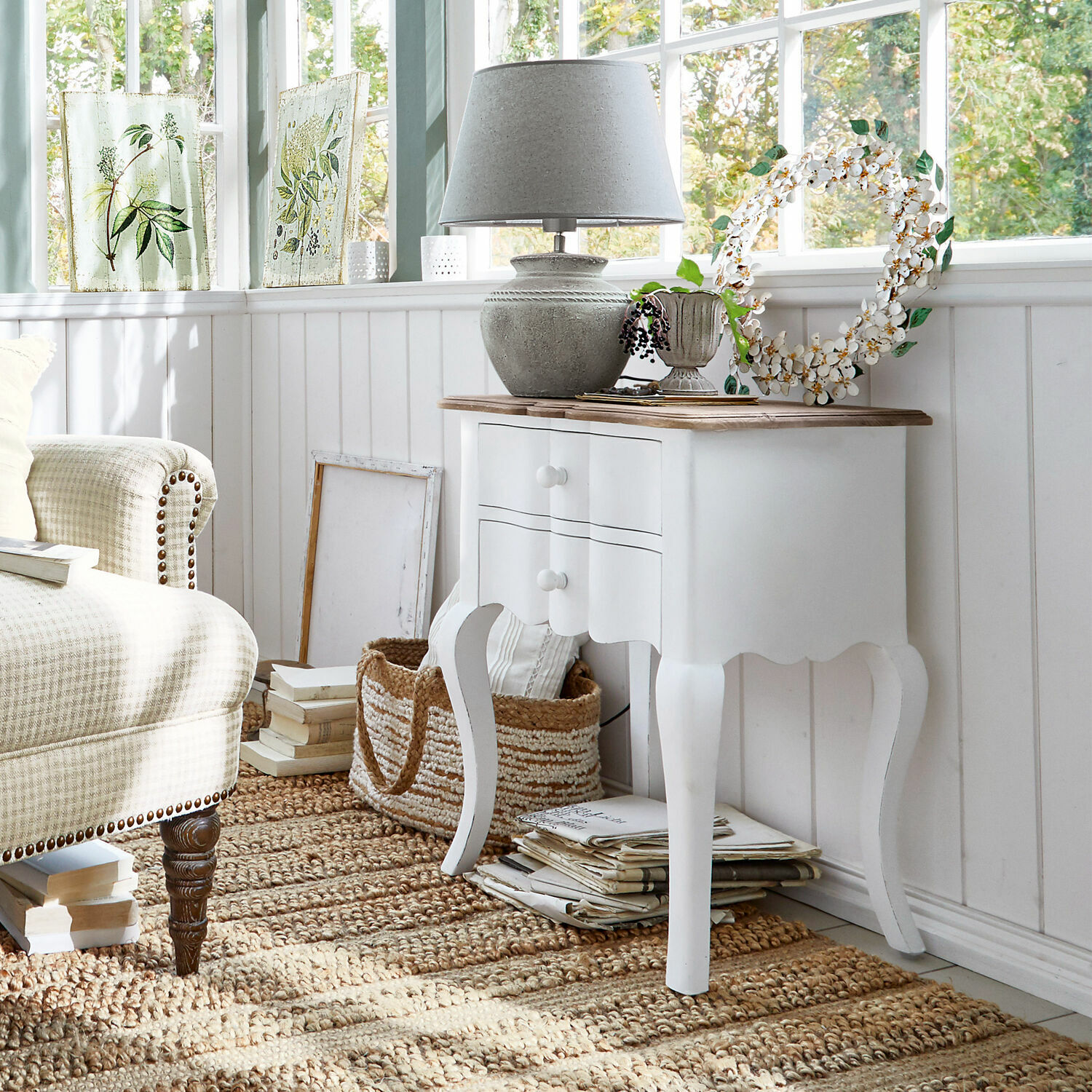Mesa auxiliar Fairchild Mesita blanca de madera con dos cajones y tapa de madera en salón luminoso estilo vintage