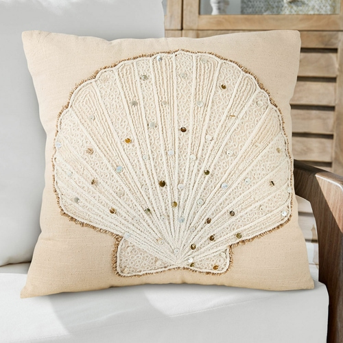 Cojín decorativo beige con concha bordada y lentejuelas, material suave, estilo marino