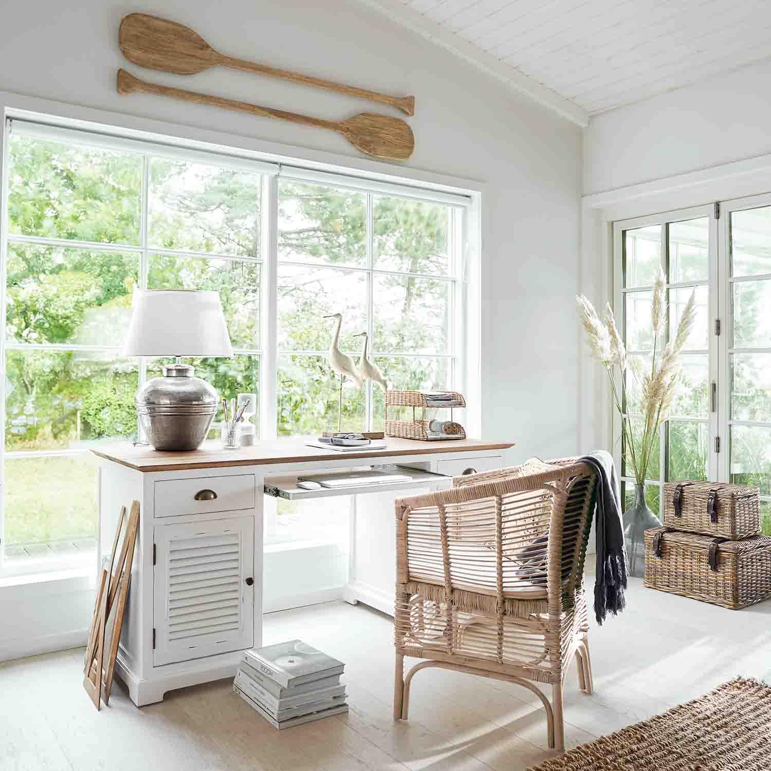 Oficina luminosa con escritorio de madera blanca y silla de mimbre en estilo natural y acogedor