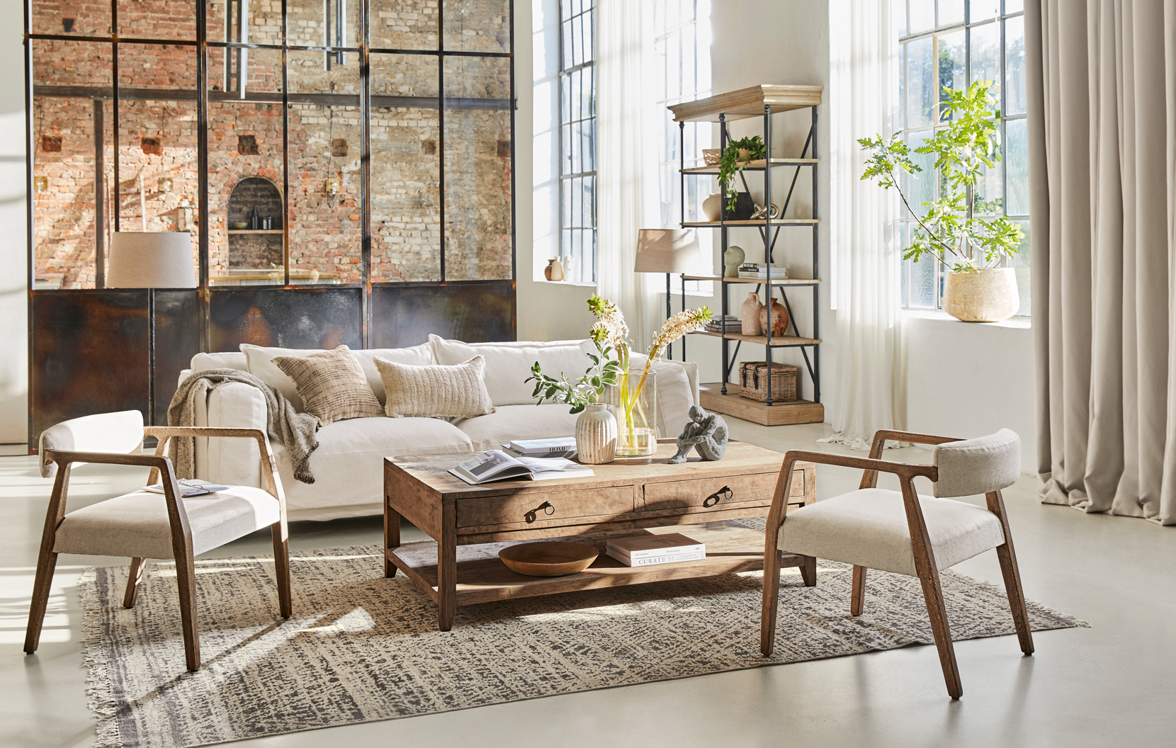 Salón estilo loft con mesa de centro de madera y sofá crema sobre alfombra texturizada