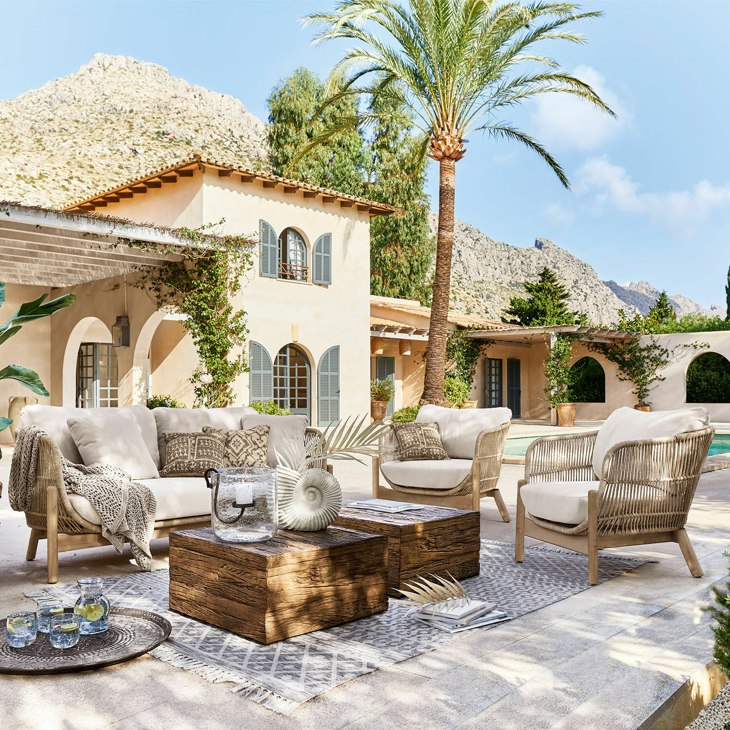 Grupo de asientos FSC®-100% Belvidere Conjunto de muebles de exterior con cojines beige y mesa de madera en terraza junto a piscina