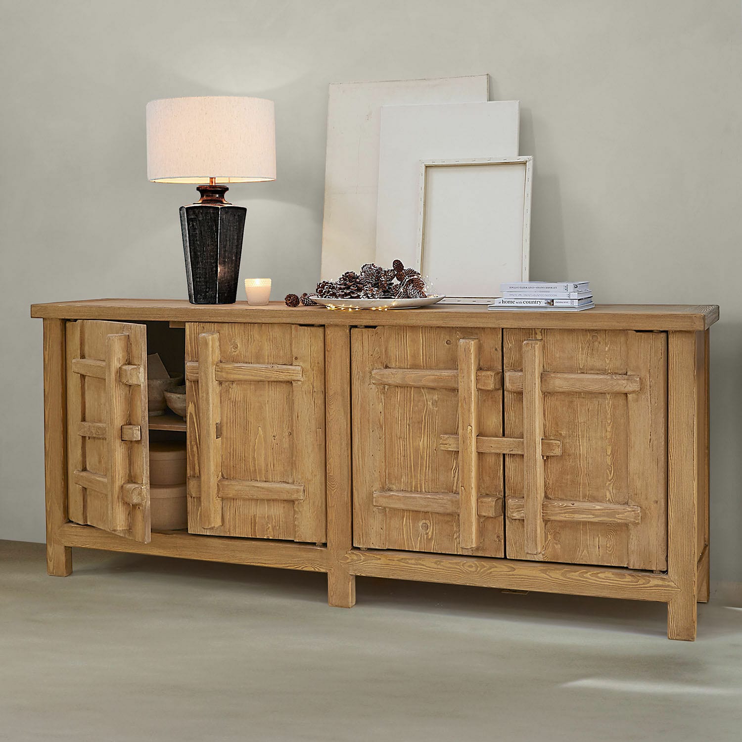 Aparador Trésorique Aparador de madera natural con cuatro puertas, lámpara y decoraciones sobre la superficie en ambiente moderno