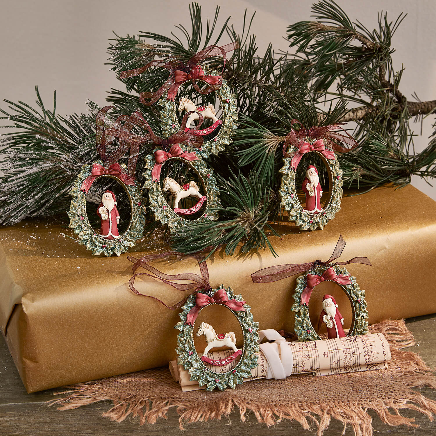 Conjunto de adornos navideños con coronas verdes, lazos rojos y figuras de Papá Noel y caballo mecedor