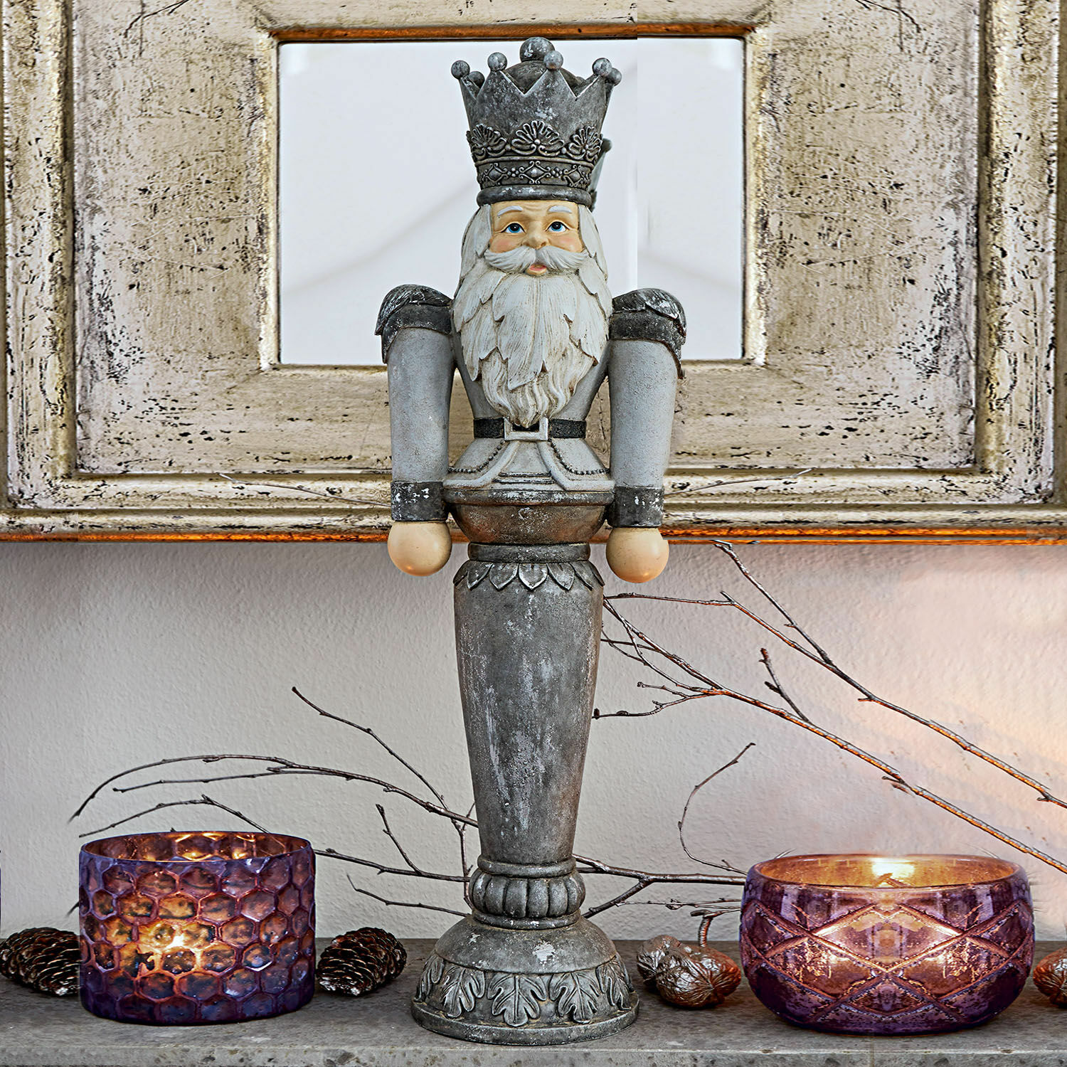 Figura decorativa Carter Figura decorativa de cascanueces de metal gris sobre mesa con portavelas morados y ramas