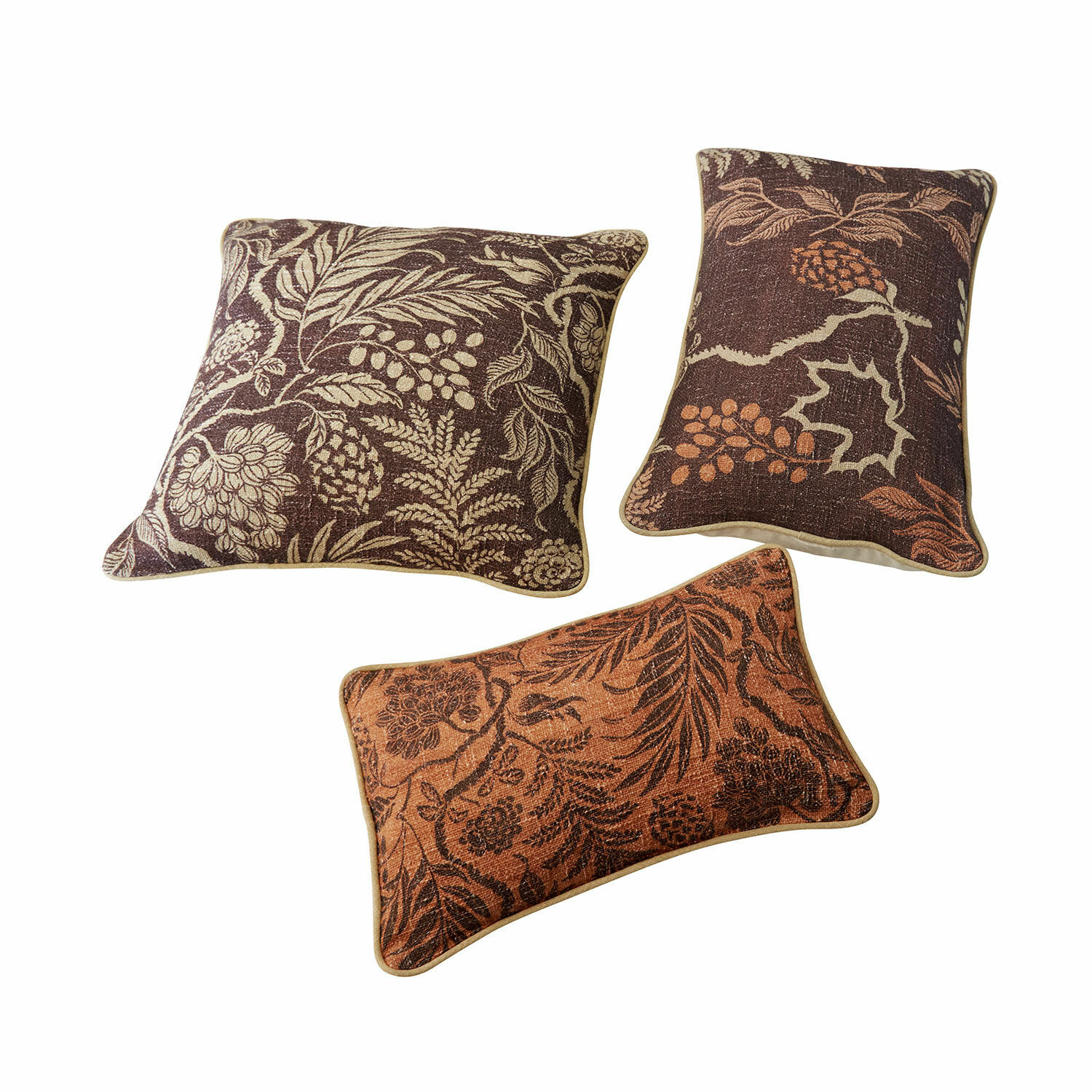 Conjunto de tres cojines decorativos con diseño de hojas en tonos marrones y naranjas para sala