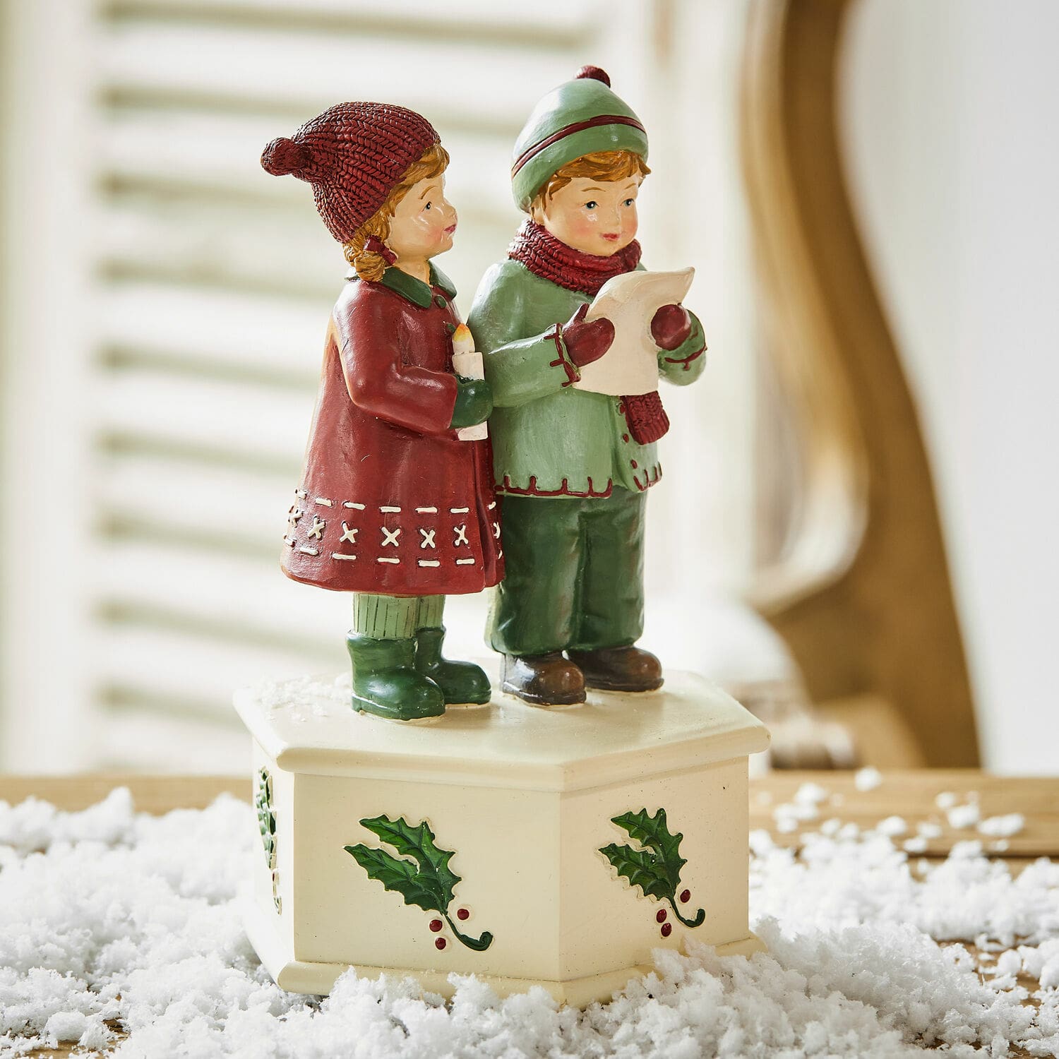 Caja de música Kalilah Figura de niños cantando villancicos sobre base crema con motivo de acebo, decoración navideña