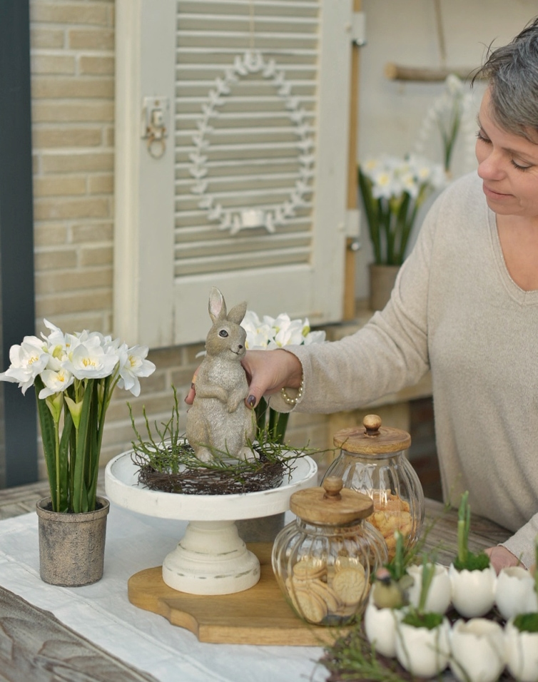 Decoración natural de Pascua con figura de conejo, flores blancas y frascos de vidrio para galletas