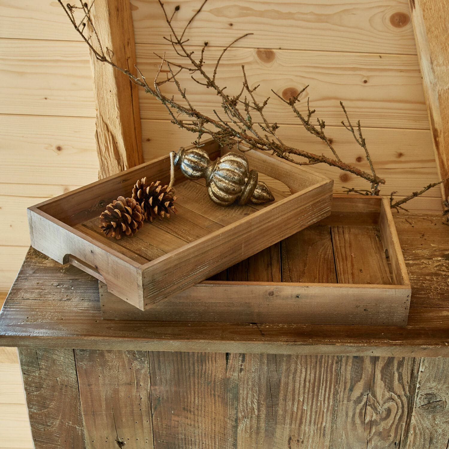 Set de 2 bandejas Kerbella Bandejas de madera natural con piñas y rama decorativa sobre mesa rústica