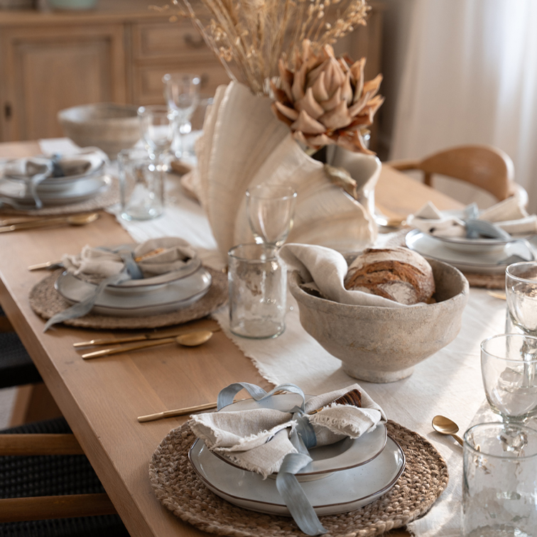 Mesa rústica con vajilla de cerámica, servilletas de lino y decoración floral seca natural