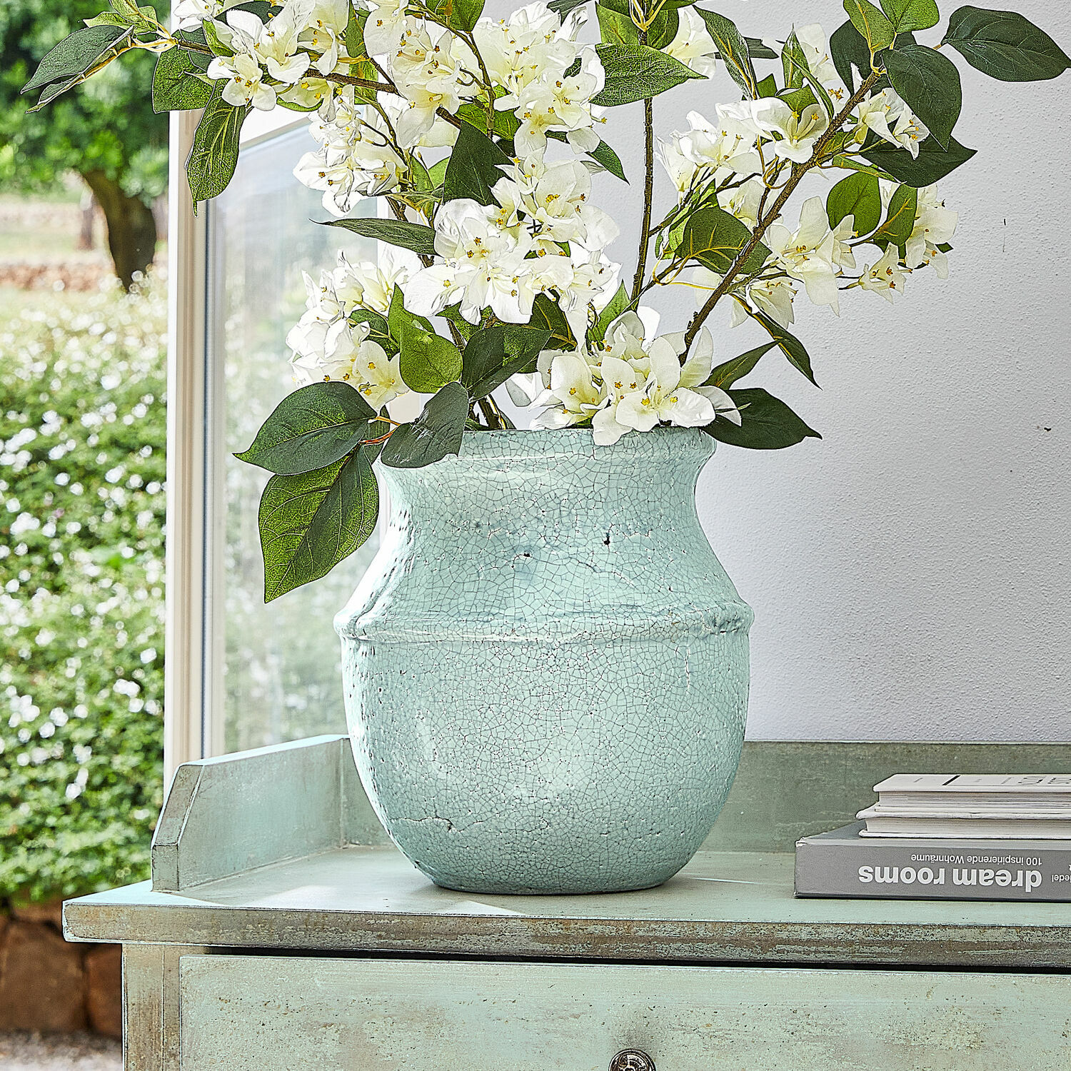 Jarrón Rosamonde Jarrón de cerámica verde menta craquelado con flores blancas sobre mesa decorativa verde
