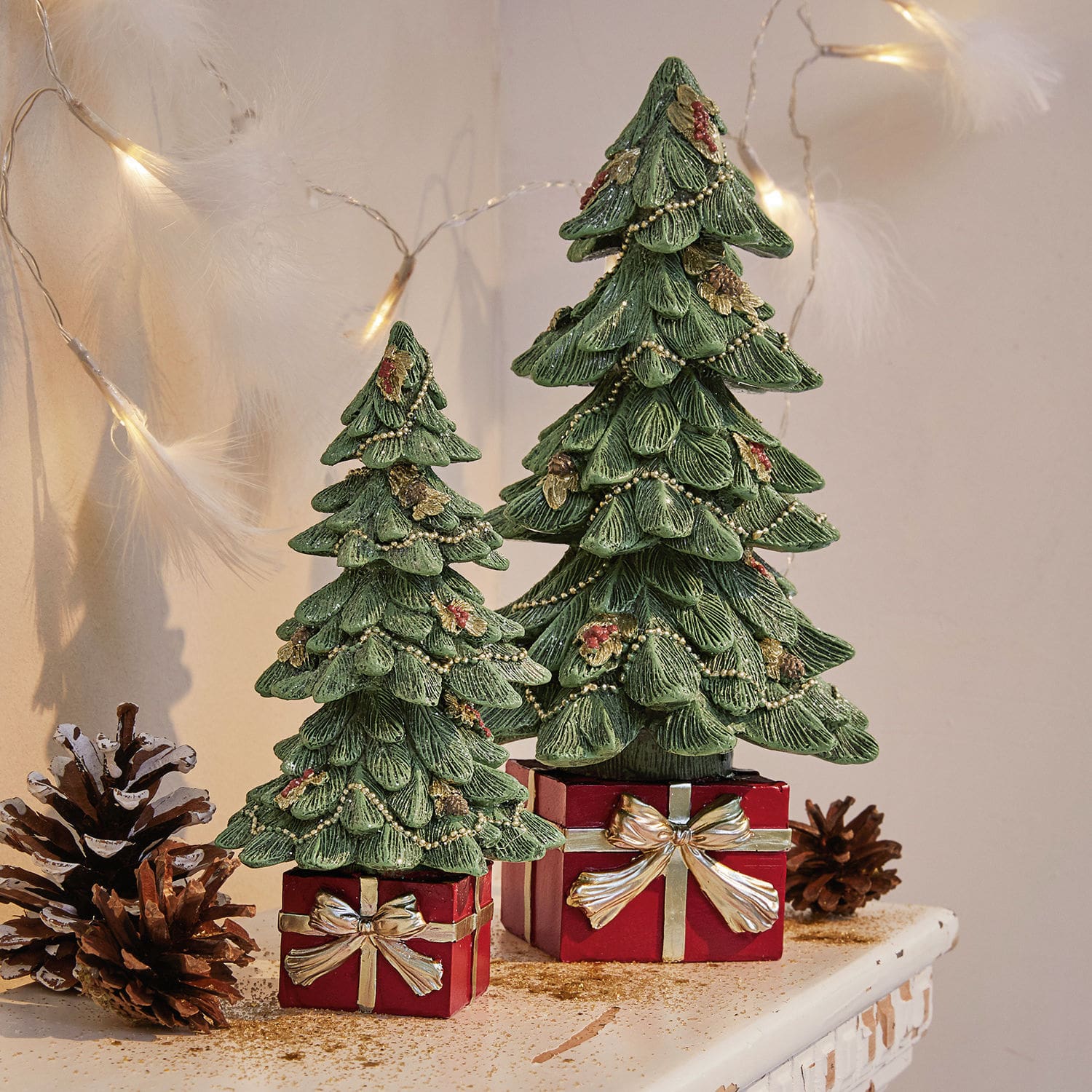 Set de 2 árboles decorativos Verne Dos árboles de Navidad decorativos verdes de material sobre cajas rojas con lazos dorados, decoración navideña
