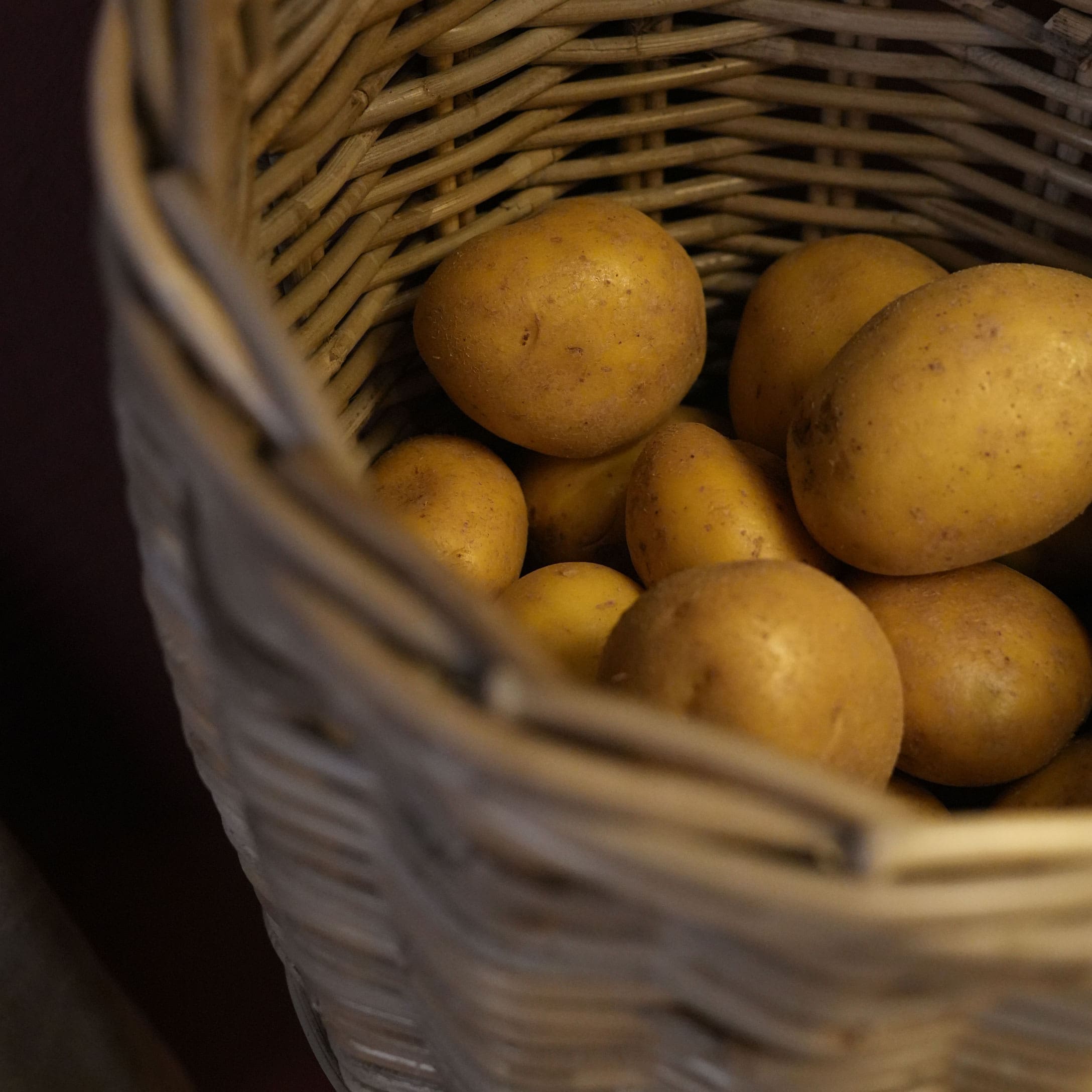 Patatas frescas en cesta de mimbre natural, verduras para cocina