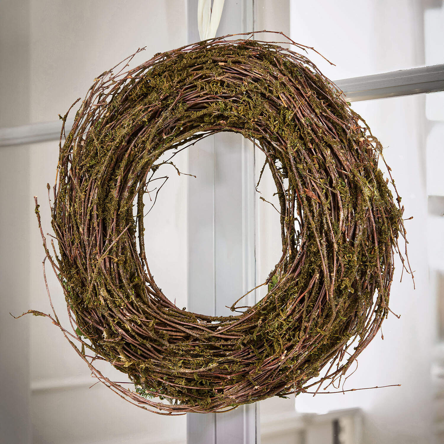 Corona natural de ramas y musgo en tonos marrón y verde para decoración de puertas e interiores