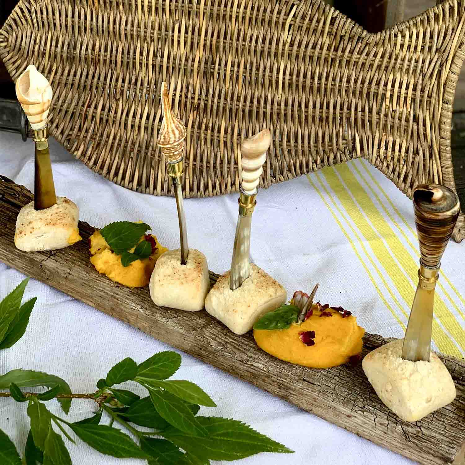 Juego de palillos decorativos con conchas sobre base de madera para aperitivos elegantes